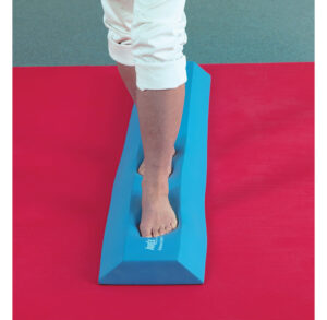 Person balancing barefoot on a blue foam beam.