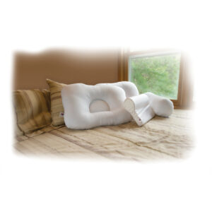 Two ergonomic memory foam pillows on a bed by a window.