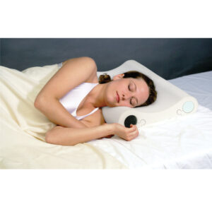 Woman peacefully sleeping on a white bed holding a black alarm clock.