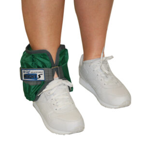 White sneakers with green ankle weights on a person's legs.