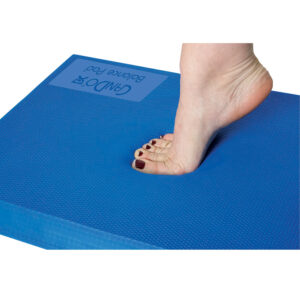 A foot pressing down on a blue foam block, showing an indentation.