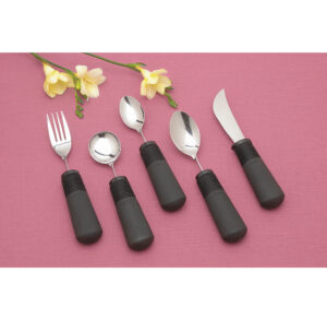 Set of black-handled cutlery with fork, spoon, and knife on pink background.