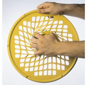 Hands squeezing a flexible yellow disc with holes.
