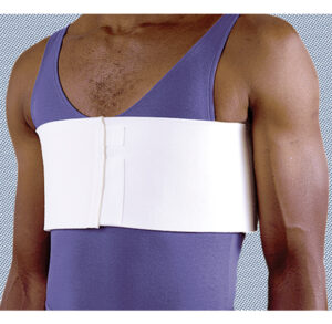 Man wearing a white chest binder over a purple tank top.